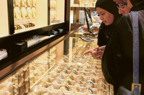 Customers select gold bracelets at a shop in the Dubai Gold Souq. [File image]
