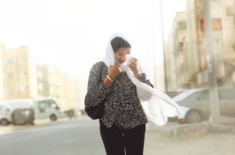 A woman covers her face during a sandstorm in Dubai. According to the met office, the weather could lead to reduced visibility. 