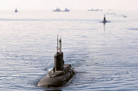 File picture shows Iranian military personnel placing a national flag on a submarine in the Strait of Hormuz. Iran's parliament has voted on Sunday to block the vital waterway, triggering a spike in global oil prices.