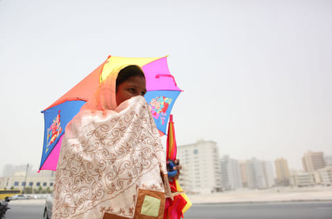 A woman braves the windy and dusty weather in Dubai. 