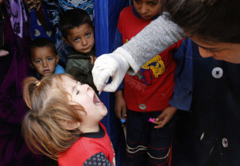 A child receives polio vaccination at an informal settlement of Syrian refugees in Zahle in the Bekaa valley October 16, 2014. 