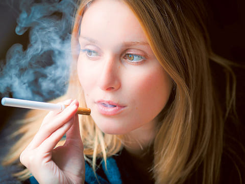A woman exhales after ‘vaping’. There is now even a vaping lexicon, according to Oxford Dictionaries, with coinages including vape pen and vape shop and e-juice.