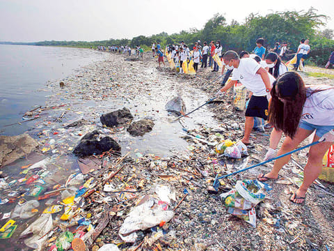 File photo: Volunteers collect garbage along the shore off Manila Bay.