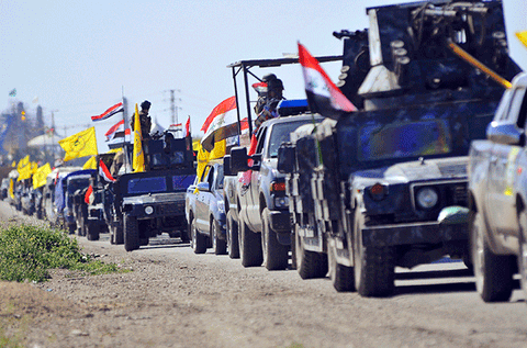 Members of the Popular Mobilization Forces stand guard at a military base near the Iraqi-Syrian border in Al Qaim, west of Iraq on January 23, 2026.