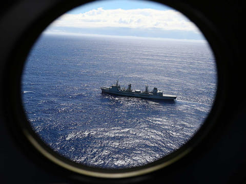 In this March 31, 2014, file photo, HMAS Success scans the southern Indian Ocean, near the coast of Western Australia, as a Royal New Zealand Air Force P3 Orion flies over, while searching for missing Malaysia Airlines Flight MH370. A Dutch survey ship Fugro Equator will finish the search of the southern Indian Ocean for Malaysia Airlines Flight 370 alone after resupplying at the southwest Australian port of Fremantle, the Australian Transport Safety Bureau, which coordinates the search, said in a statement.
