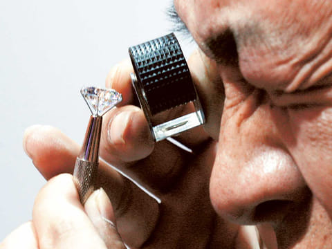 Demand for synthetic diamond jewellery has been high, according to Pandora, which sells more pieces of jewellery than any other company in the world [File image: An investor examines the clarity of a diamond]