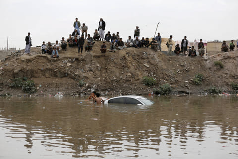 File picture from Sanaa shows volunteers trying to retrieve a car submerged under flood waters. 