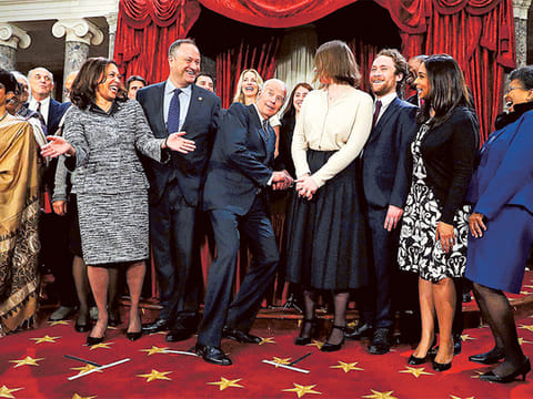 Vice-President Joe Biden (centre) ducks down so all of the family of Senator Kamala Harris (second right) can be seen for a group photo during a mock oath ceremony.
