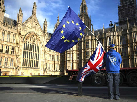 AA man holds the EU and UK flags outside the Houses of Parliament, in central London 