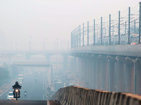 Vehicles travelling along a road that is shrouded in smog in Delhi. The smog has been caused by seasonal burning of crop stubble and emissions from vehicles and industry.