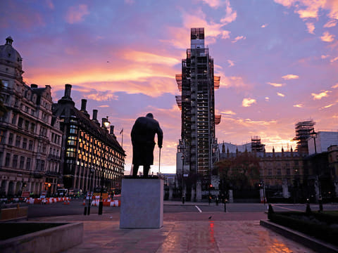 The sun rises as seen in Parliament Square with the statue of former Prime Minister Winston Churchill in the foreground in London