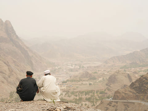 Two men look over the mountains near the Khyber Pass.