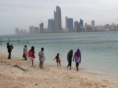 Abu Dhabi residents walk at the beach