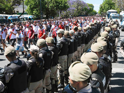 Security forces stand guard as River Plate’s supporters leave the Monumental stadium in Buenos Aires.