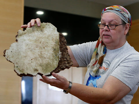 Jacquita Gonzales, the wife of in-flight supervisor Patrick Francis Gomes, who was onboard the missing Malaysia Airlines MH370, displays debris believed to belong to MH370 before handing over to Malaysia's Transport Minister Anthony Loke Siew Fook in Putrajaya, Malaysia November 30, 2018.