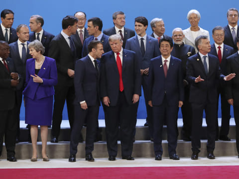 US President Donald Trump, front center, listens to France's President Emmanuel Macron as they pose with world leaders for a group picture at the start of the G20 Leader's Summit inside the Costa Salguero Center in Buenos Aires, Argentina. 