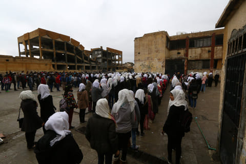 Children stand in line at a playground of a school in Raqqa, Syria. 