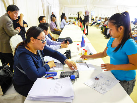 An amnesty seeker talks to an official from the Philippine Consulate, at the Al Aweer Federal Authority for identity and citizenship, General Directorate of Residency and Foreigners affairs Dubai. 
