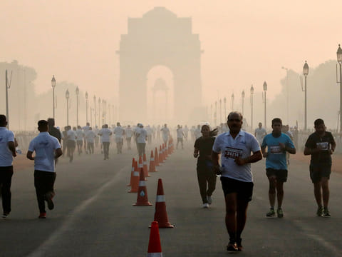 Participants run during a half marathon on a smoggy morning in New Delhi, India