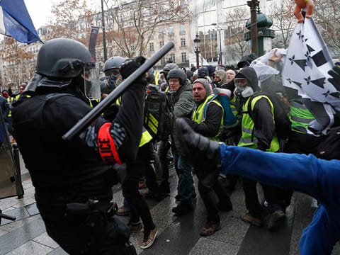 Police officers clash with demonstrators wearing yellow vests in Paris, Saturday, Dec. 8, 2018. 
