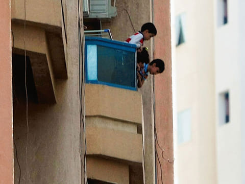 Kids leaning dangerously from balcony of an apartment in Al Nahda, Sharjah.