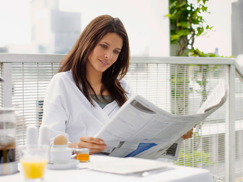 A woman reading a newspaper.
