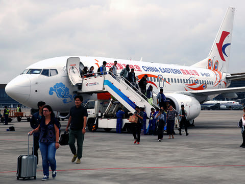 Airline passengers exit a Boeing 737 operated by China Eastern Airlines, which will own a majority stake in China's new carrier.