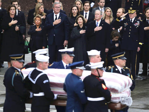 The flag-draped casket of former President George H.W. Bush is carried by a joint services military honor guard