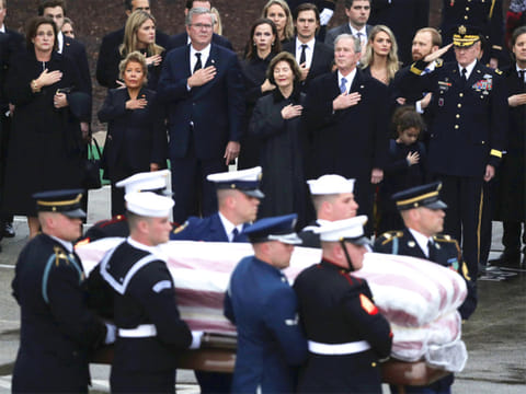 The flag-draped casket of former President George H.W. Bush is carried by a joint services military honor guard