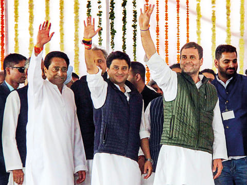 Congress president Rahul Gandhi (right), newly sworn in Madhya Pradesh Chief Minister Kamal Nath (left) and party MP Jyotiraditya Scindia wave at the crowd during the swearing in ceremony in Bhopal.