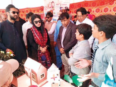 Students show Senator Sassui Palijo how their project works at the Laar Science Festival in Thatta.
