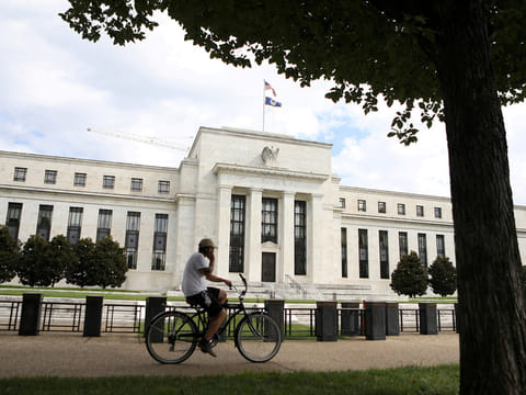 A cyclist passes the Federal Reserve building in Washington, DC, U.S., August 22, 2018. 