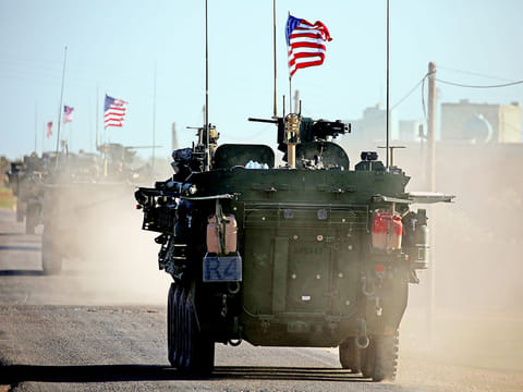 A convoy of US armoured vehicles drives near the village of Yalanli on the western outskirts of the northern Syrian city of Manbij in March 2017. 