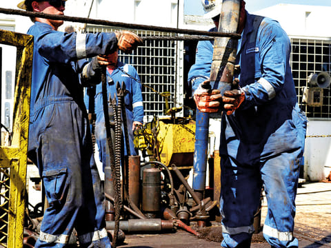 Shale explorers returned to growth mode this week. A drilling crew moves drill pipe into place on an oil rig in the Permian Basin near Wink, Texas.