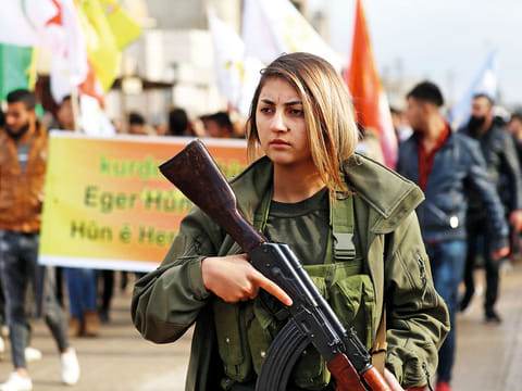 A fighter from the Syrian Democratic Forces (SDF) participates in a demonstration in the northeastern Syrian Kurdish-majority city of Qamishli on December 28, 2018.