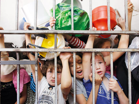 Palestinian children wait to receive food at a soup kitchen. 