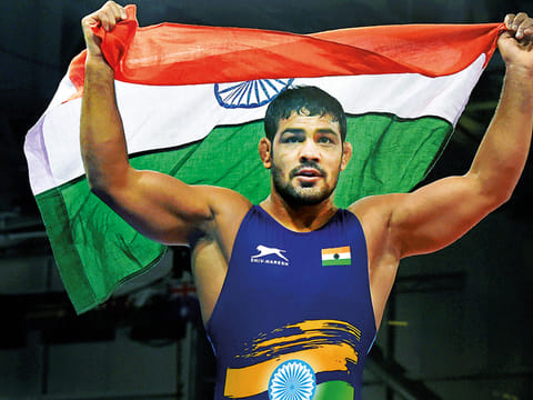 India's Sushil Kumar celebrates holding tricolour after winning a gold medal in the men's freestyle 74kg wrestling final bout against South Africans' Johannes Botha at the Commonwealth Games 2018 in Gold Coast, on Thursday. 