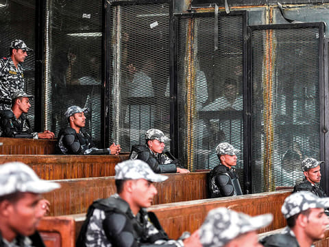 File picture shows members of Egypt's banned Muslim Brotherhood inside a glass dock during their trial in Cairo on July 28, 2018.