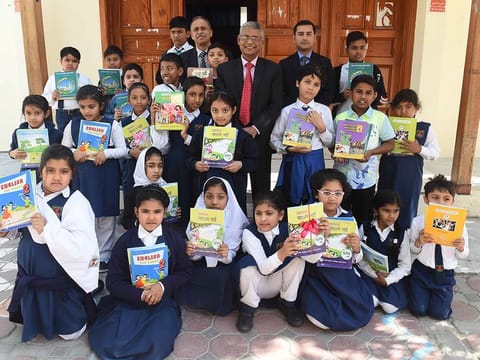 Students of Shaikh Khalifa Bin Zayed Bangladesh Islamia School , Abu Dhabi with Mir Anisul Hasan, Principal, and other officials during free book distribution at the school yesterday.