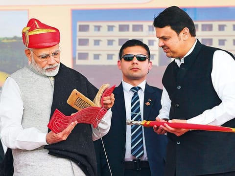 Indian PM Narendra Modi (left) is presented a memento by Maharashtra Chief Minister Devendra Fadnavis during the dedication of the Solapur-Osmanabad section of National Highway-52 in Solapur yesterday.