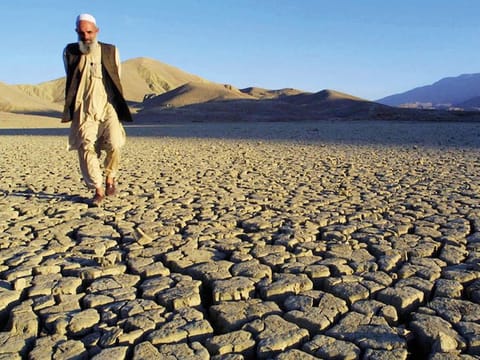 A man walks on the dried, cracked landscape near Hanna Lake near Quetta, Pakistan. AFP