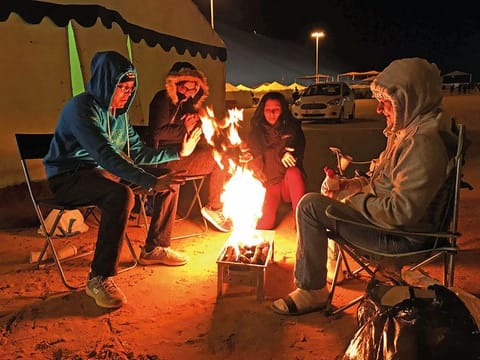 Fun Drive participants unwind next to their tent at the main campsite in Liwa on Friday night. 