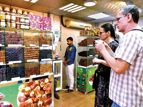 Ivan Susulik (right) and his wife from the Czech Republic at a shop in Mina Vegetable and Fruits Markets’ dates souq. They were impressed by the variety of dates sold at the market.