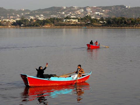 A woman takes a selfie while riding on a boat at the Rawal Lake in Islamabad, Pakistan. Image for illustrative purposes only. 