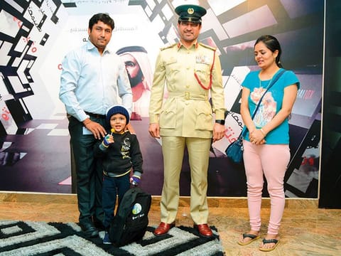 Brigadier Saeed Hamad Bin Sulaiman with the five-year-old boy and his parents at Al Rashidiya police station.