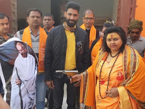 Pooja Shakun, national secretary of the Hindu Mahasabha, shooting an effigy of Gandhi