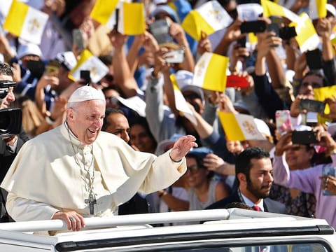 Pope Francis waves to the crowd as he arrives to lead mass Zayed Sports City Stadium in Abu Dhabi. 
