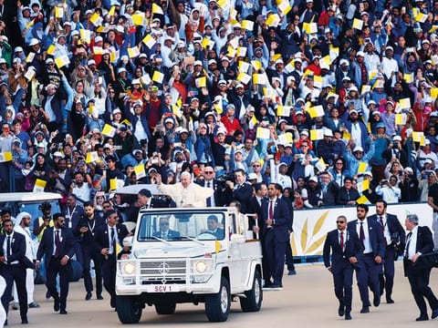 Pope Francis waves to thousands of worshippers at the Zayed Sports City Stadium. 