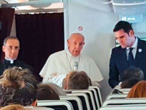 Pope Francis chats with journalists on board his plane after taking off from Abu Dhabi. The pontiff left for Rome after his three-day visit to the UAE.