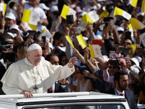 Pope Francis, on his visit to the UAE, waves to the crowd before the Papal mass